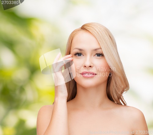 Image of beautiful woman touching her eye area