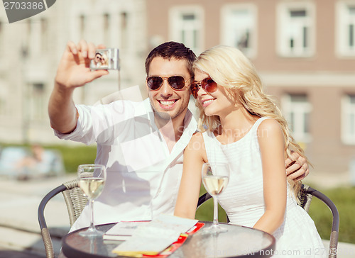 Image of couple taking photo in cafe