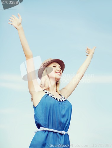 Image of girl with hands up on the beach