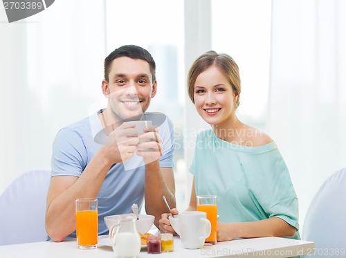 Image of smiling couple having breakfast at home