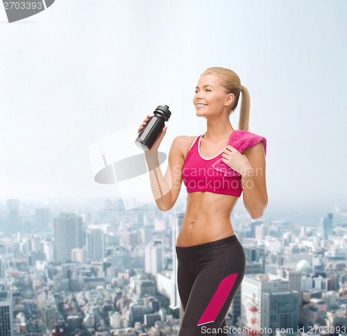 Image of sporty woman drinking water from sportsman bottle