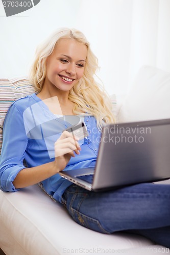 Image of smiling woman with laptop computer and credit card