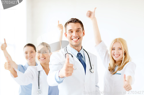 Image of smiling male doctor in front of medical group