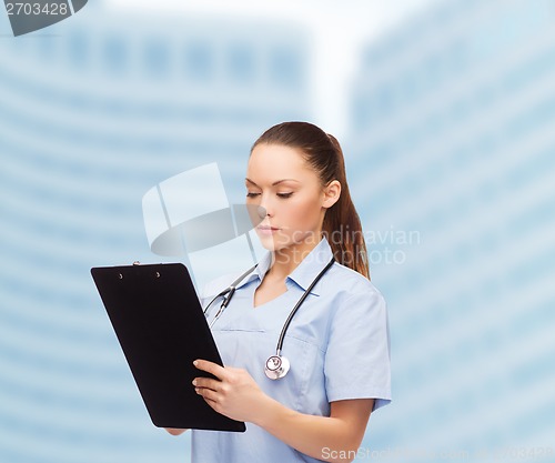 Image of serious female doctor or nurse with stethoscope