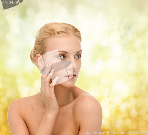 Image of beautiful woman touching her face skin