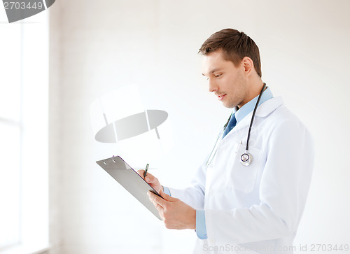 Image of smiling male doctor with stethoscope and clipboard