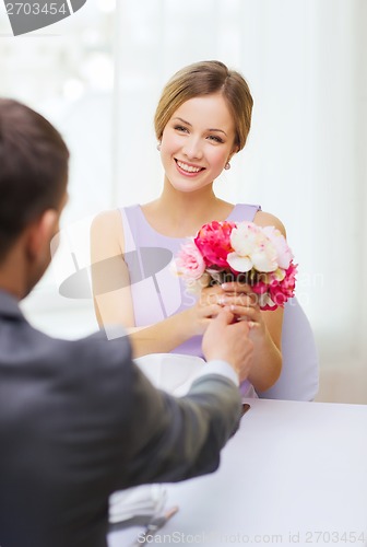 Image of smiling woman recieving bouquet of flowers