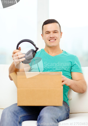 Image of opening cardboard box and taking out headphones