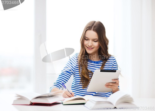 Image of smiling student girl with tablet pc and books