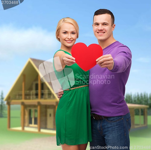 Image of smiling couple holding big red heart