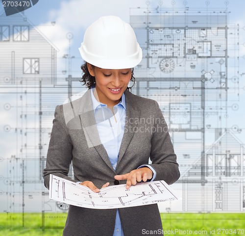 Image of businesswoman in white helmet with blueprint