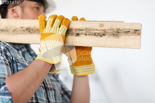 Image of close up of male in gloves carrying wooden boards