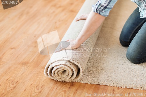 Image of close up of male hands unrolling carpet