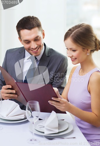 Image of smiling couple with menu at restaurant