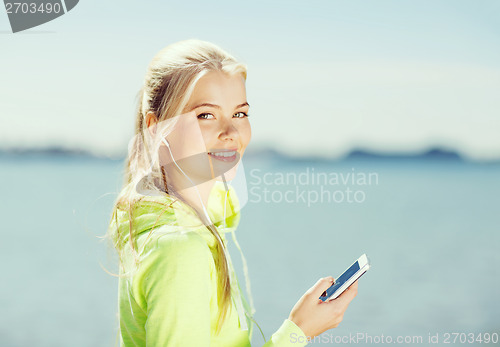 Image of woman listening to music outdoors