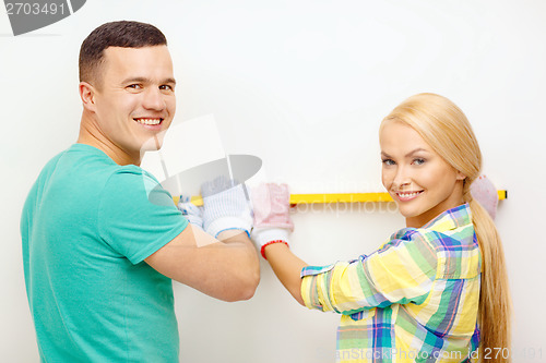 Image of couple building using spirit level to measure