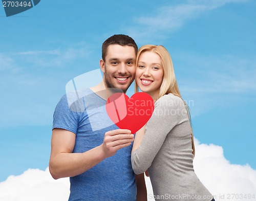 Image of smiling couple holding big red heart
