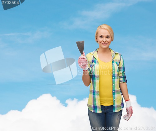 Image of smiling female worker in gloves with spatula