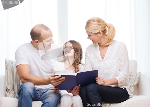 Image of smiling parents and little girl with at home