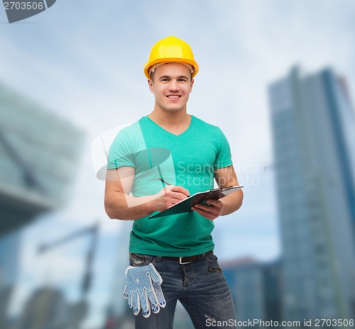 Image of smiling man in helmet with clipboard