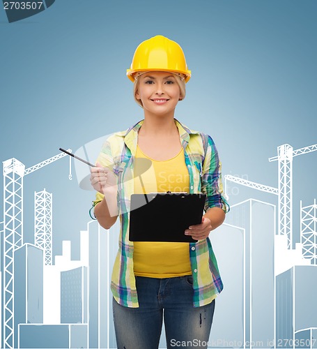 Image of smiling woman in helmet with clipboard