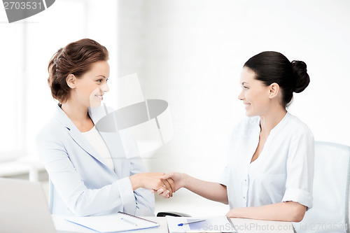 Image of businesswomen shaking hands in office