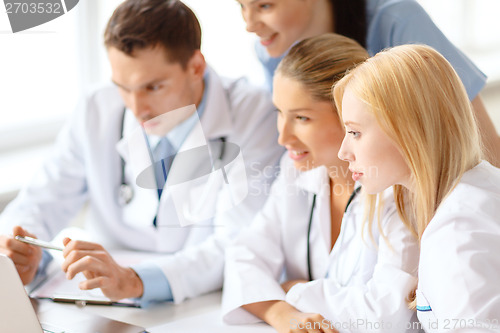 Image of group of doctors looking at laptop computer