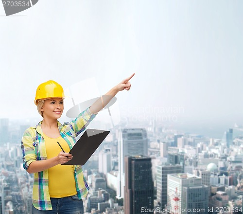 Image of smiling woman in helmet with clipboard