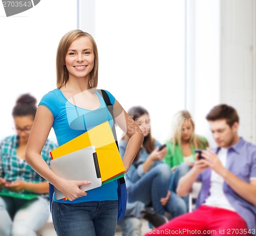 Image of smiling student with bag, folders and tablet pc