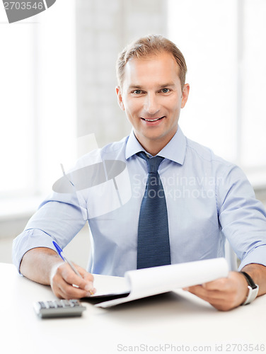 Image of businessman with notebook and calculator