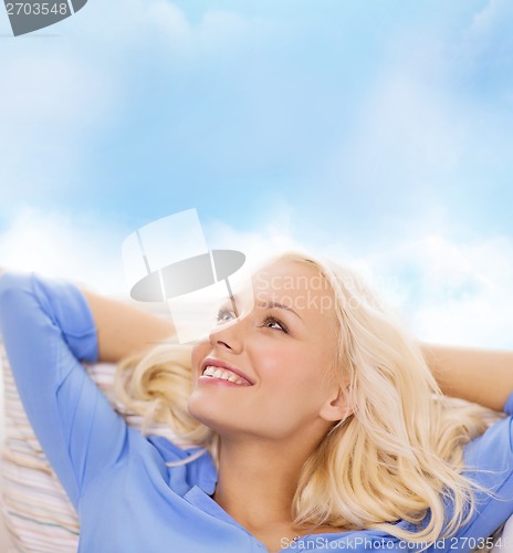 Image of smiling young woman lying on sofa