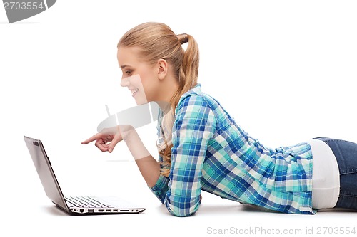 Image of smiling woman with laptop and pointing finger