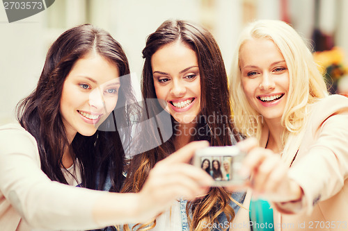 Image of beautiful girls taking picture in cafe in city