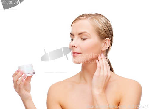 Image of woman applying cream on her skin