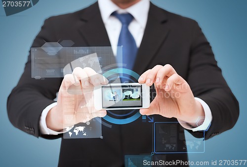 Image of businessman showing smartphone with blank screen