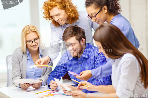 Image of smiling team with color samples at office