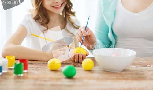 Image of close up of little girl and mother coloring eggs