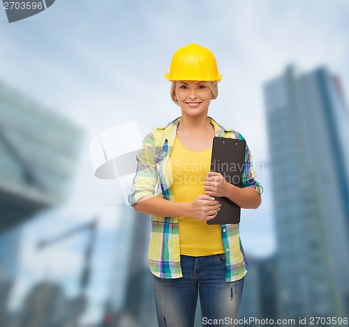 Image of smiling woman in helmet with clipboard