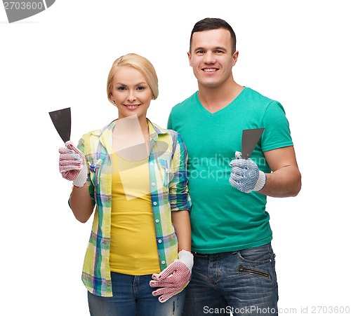 Image of smiling couple in gloves with spatula
