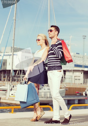 Image of young couple in duty free shopping bags