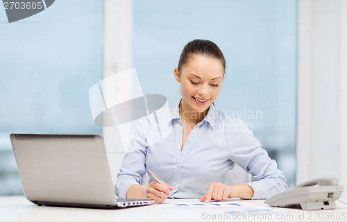 Image of businesswoman with phone, laptop and files
