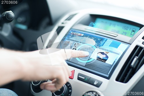 Image of man using car control panel to read news