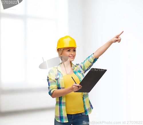 Image of smiling woman in helmet with clipboard