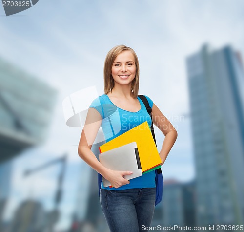 Image of smiling student with bag, folders and tablet pc