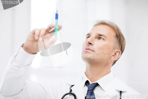 Image of male doctor holding syringe with injection