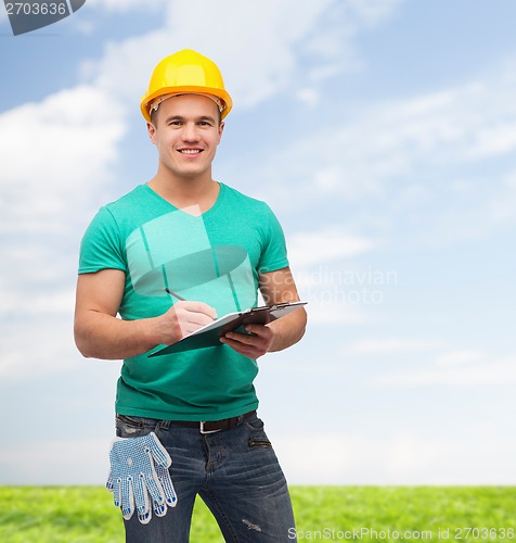 Image of smiling man in helmet with clipboard