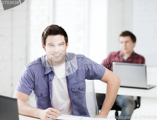 Image of smiling student with laptop at school