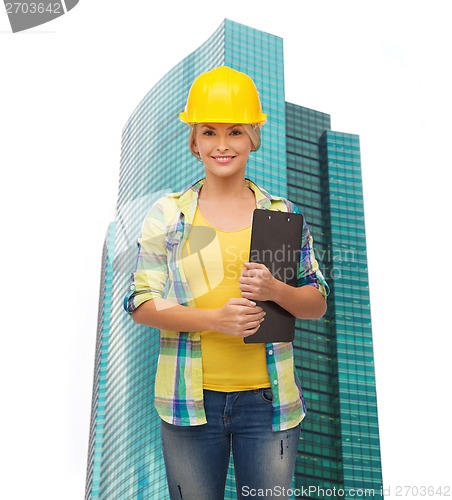 Image of smiling woman in helmet with clipboard