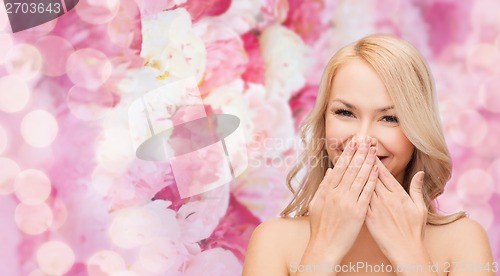 Image of beautiful woman covering her mouth