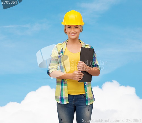 Image of smiling woman in helmet with clipboard